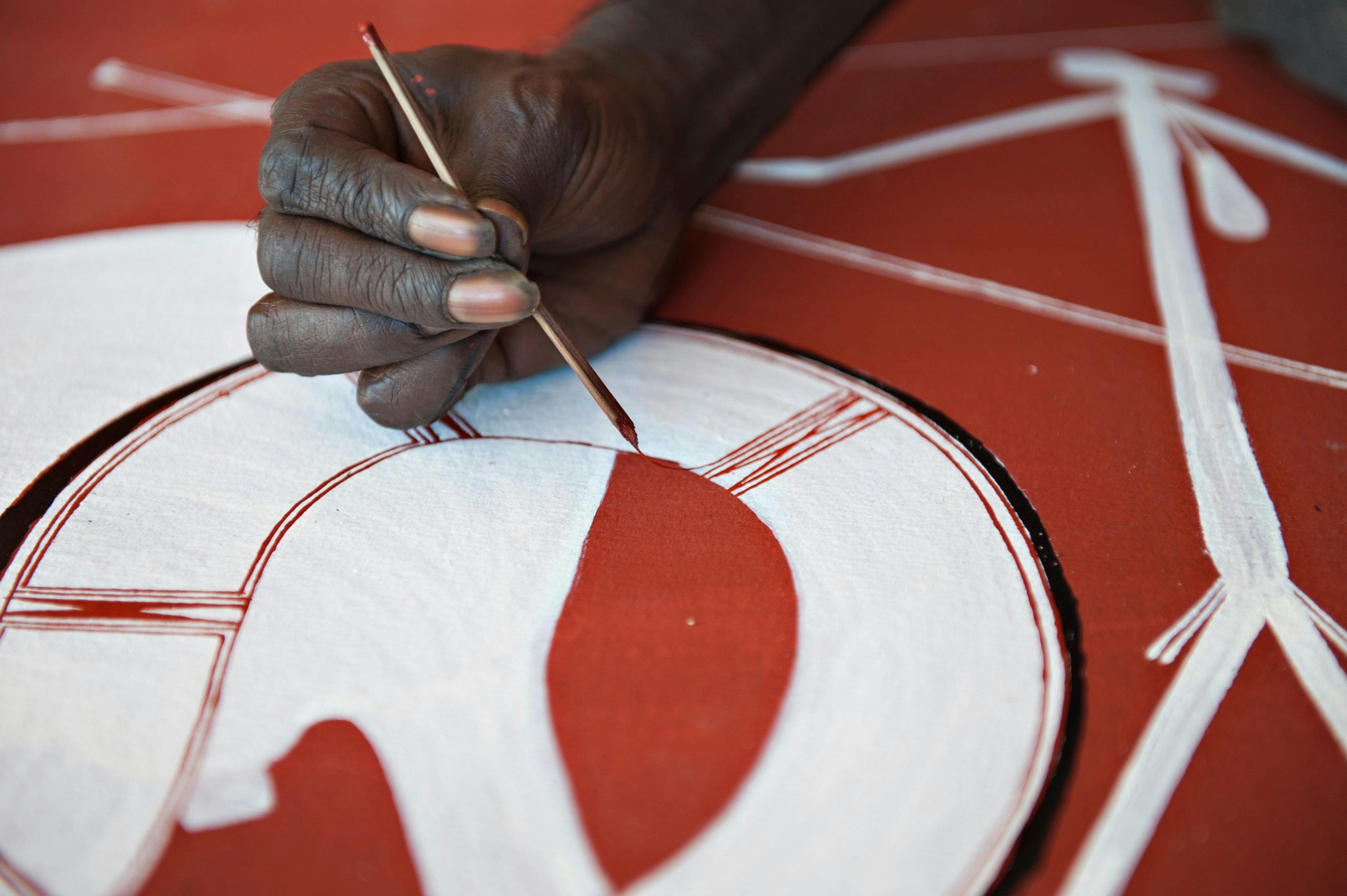 Injalak artist using traditional (rarrk) methods on a canvas