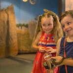 two children meeting snakes and lizards during the Junior Reptile Rangers program at Croc Cove