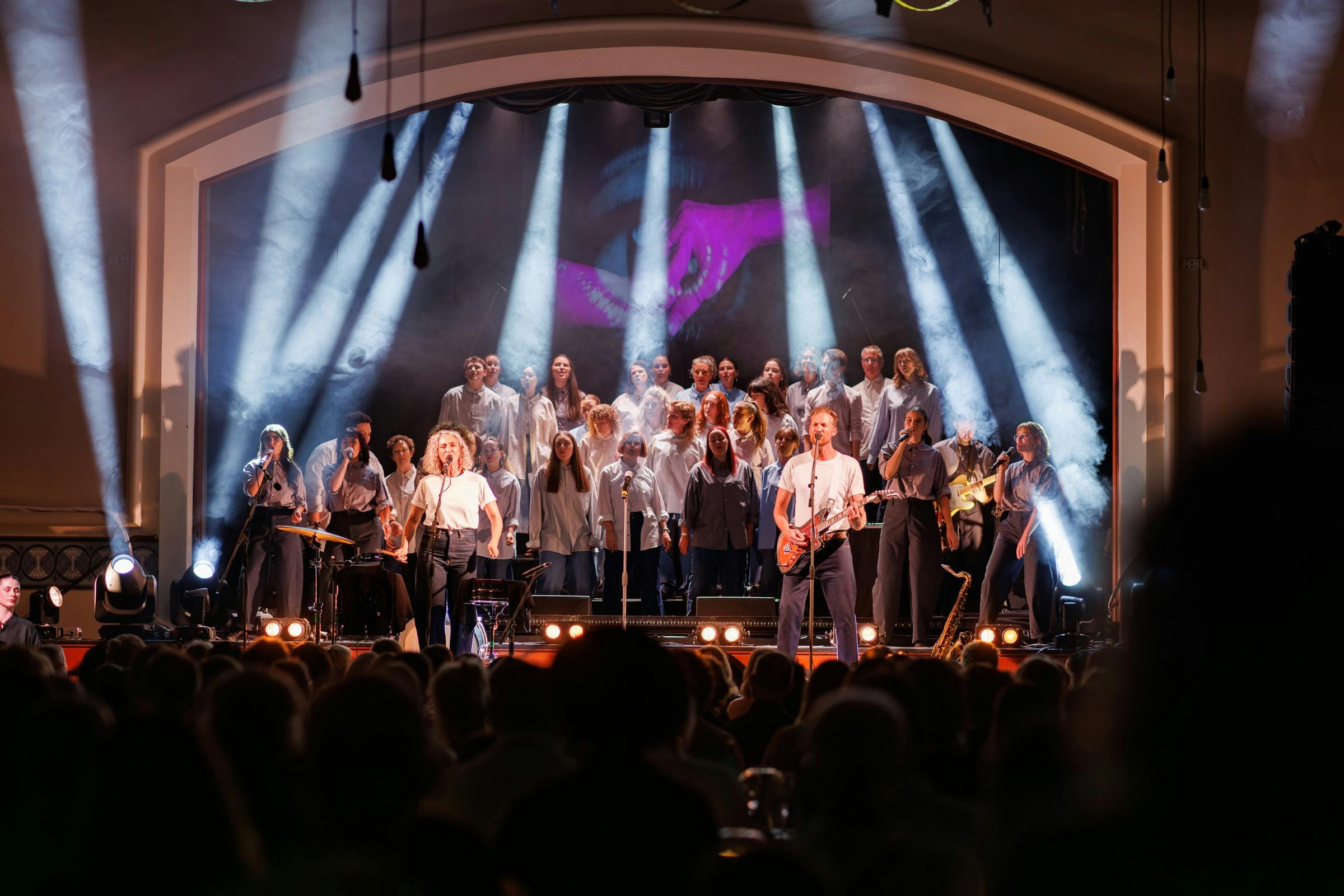 Mama Kin Spender performing on stage with full choir