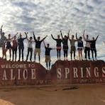 Happy Group on the welcome to Alice springs sign at the end of a great tour
