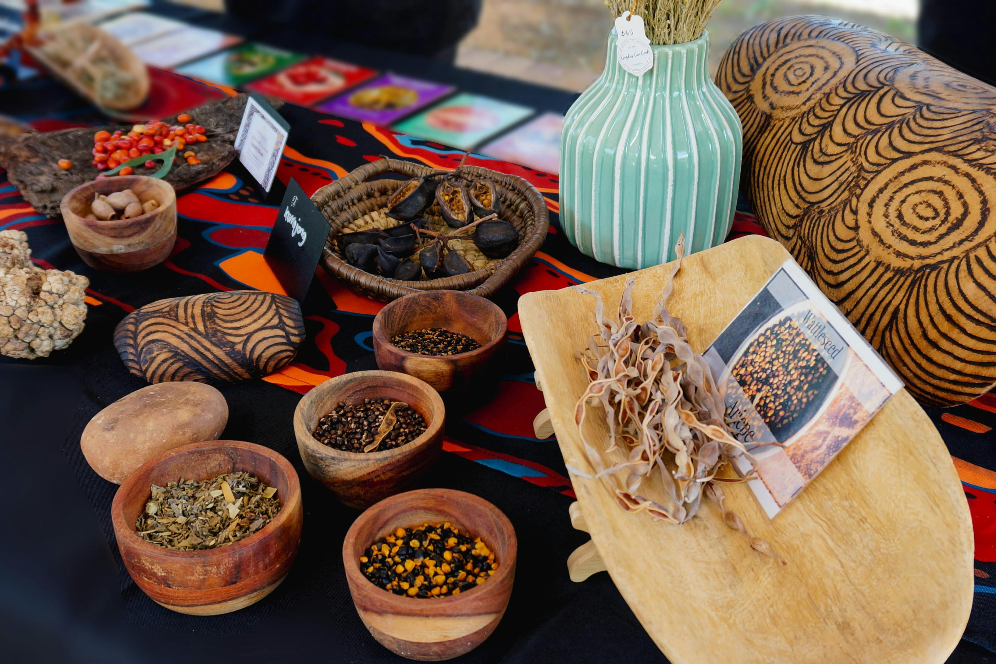 A display of bush food seeds, nuts, fruits in bowls on a table