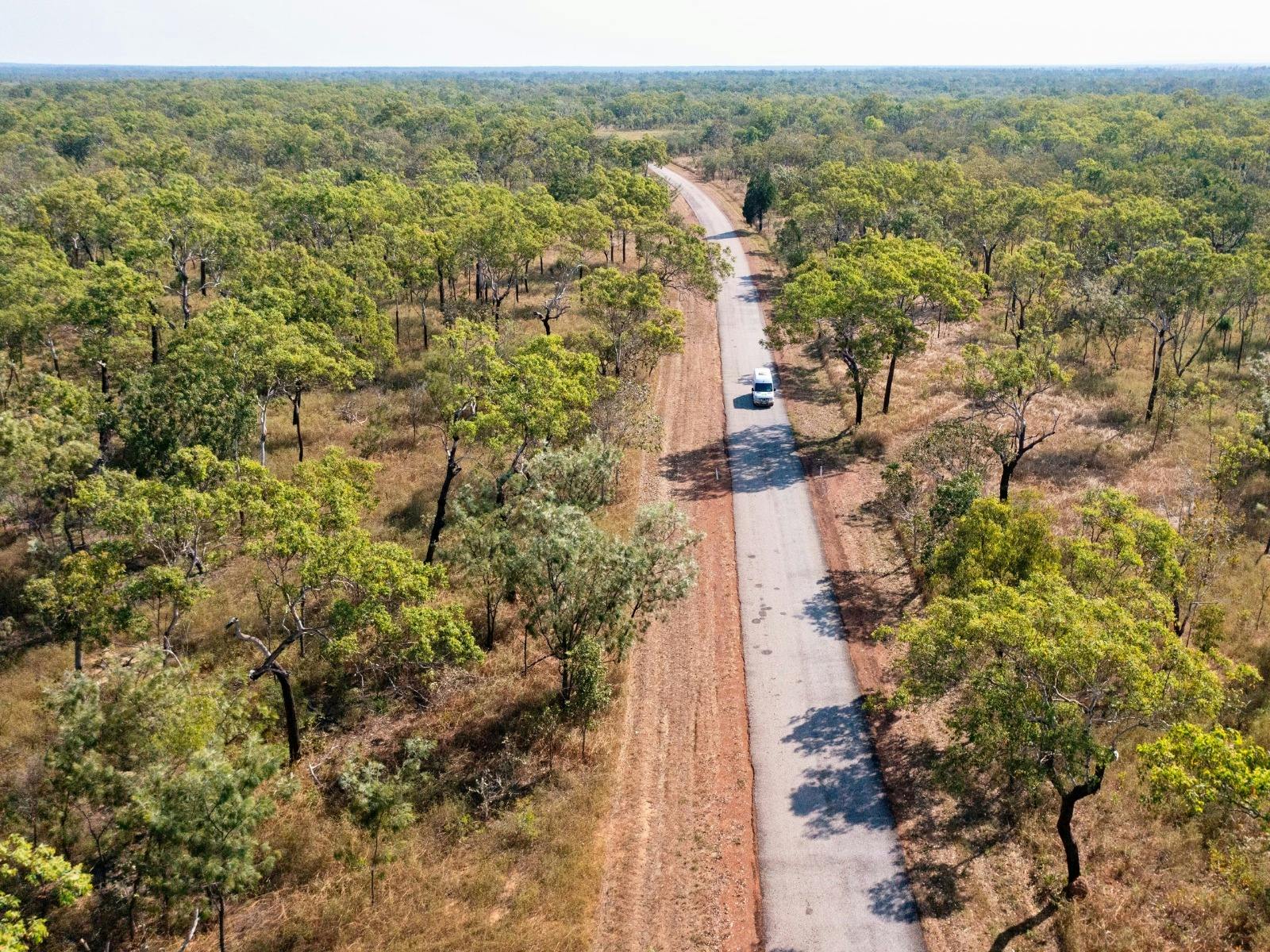 A van travels through Litchfield National Park on a bright, sunny day