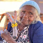 Artist Martha Protty in Kaltukatjara, NT, with her Tjanpi papa (dog) sculpture.