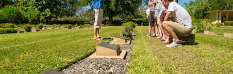 family standing over grave talking to tour guide
