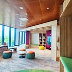 Bookshelves in a brightly lit room with a wall of windowds