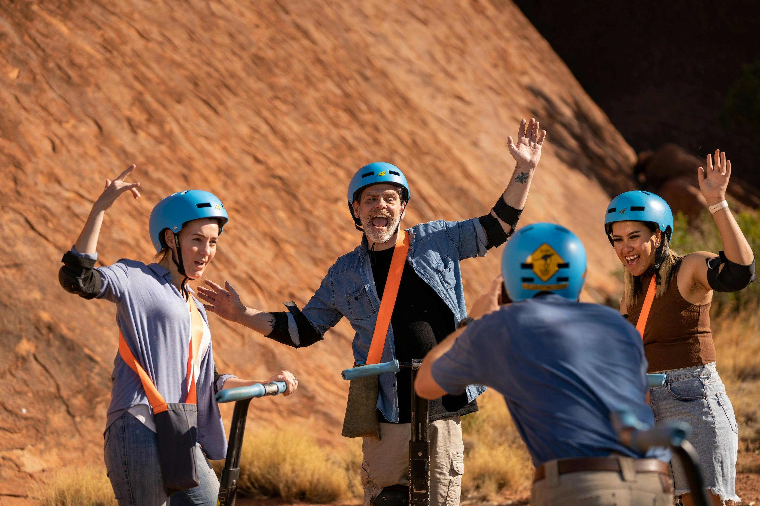 A group of friends pose on their Segways as their guide photographs them.