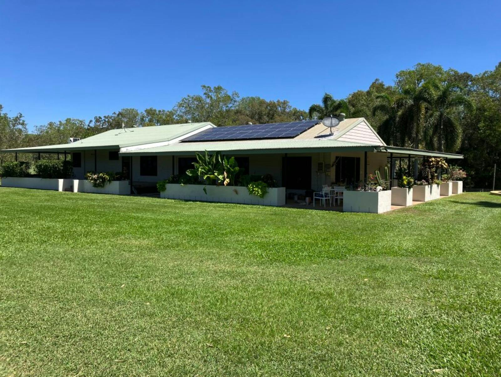 Front of house with veranda and gardens