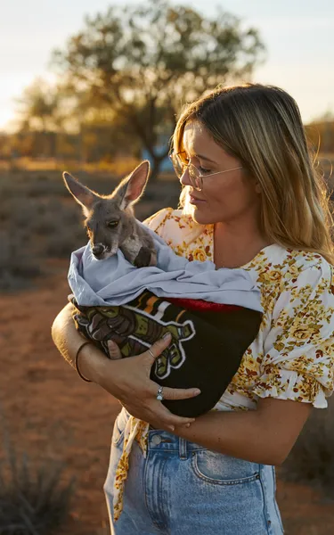 woman holding kangaroo in alice springs