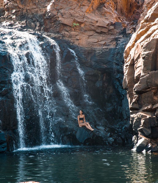woman relaxing on the rocks next to leliyn falls,-d-,jpg