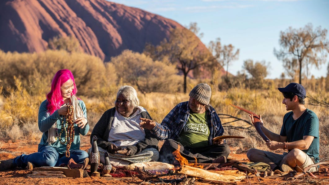 Group of people sitting together at Maruku Arts near Uluru