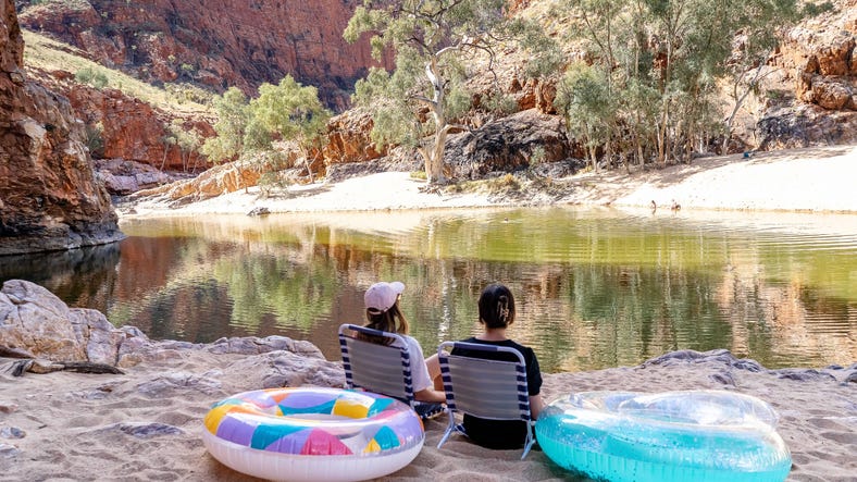 Two people sitting by Ormiston gorge