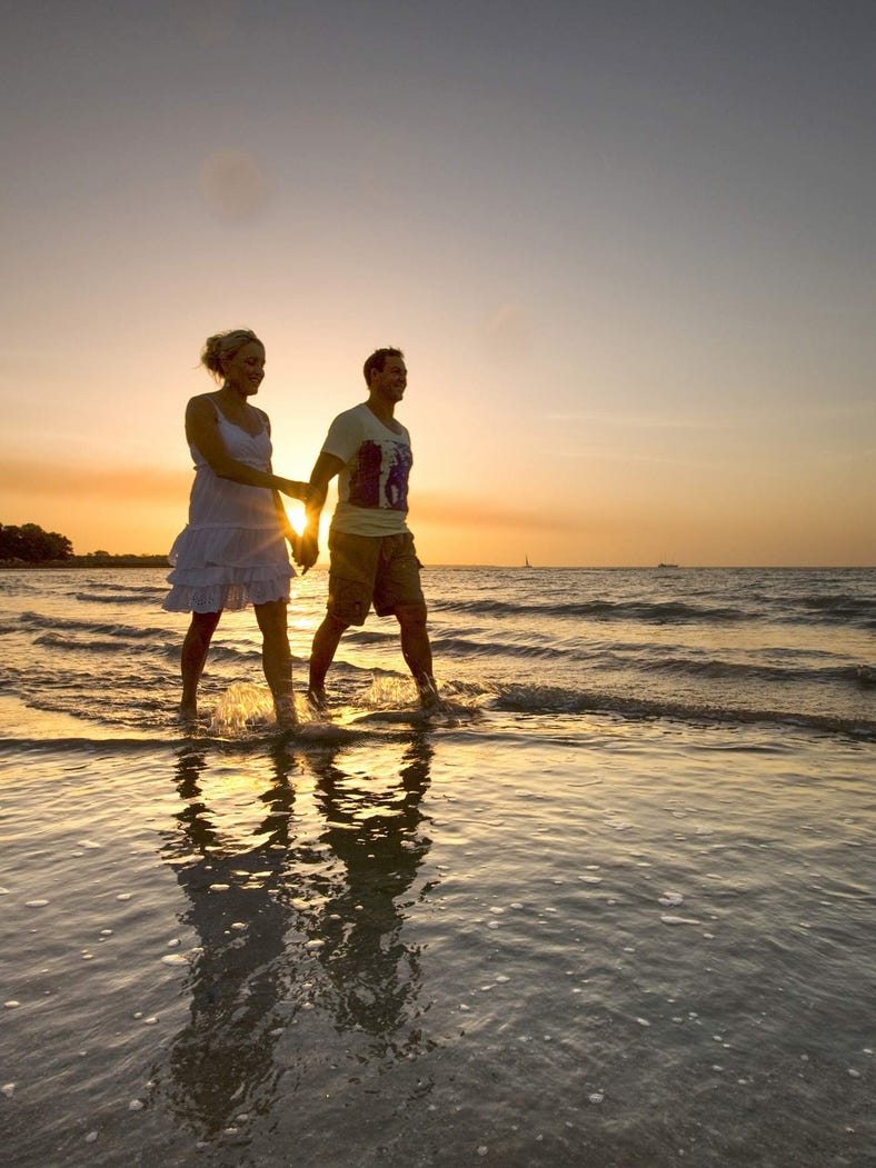 Couple walking the Mindil Beach at sunset