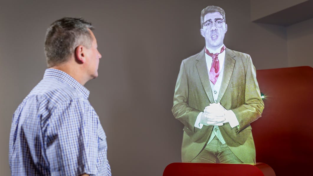 a-visitor-listening-to-a-hologram-display-at-the-royal-flying-doctor-service-rfds-darwin-tourist-fac