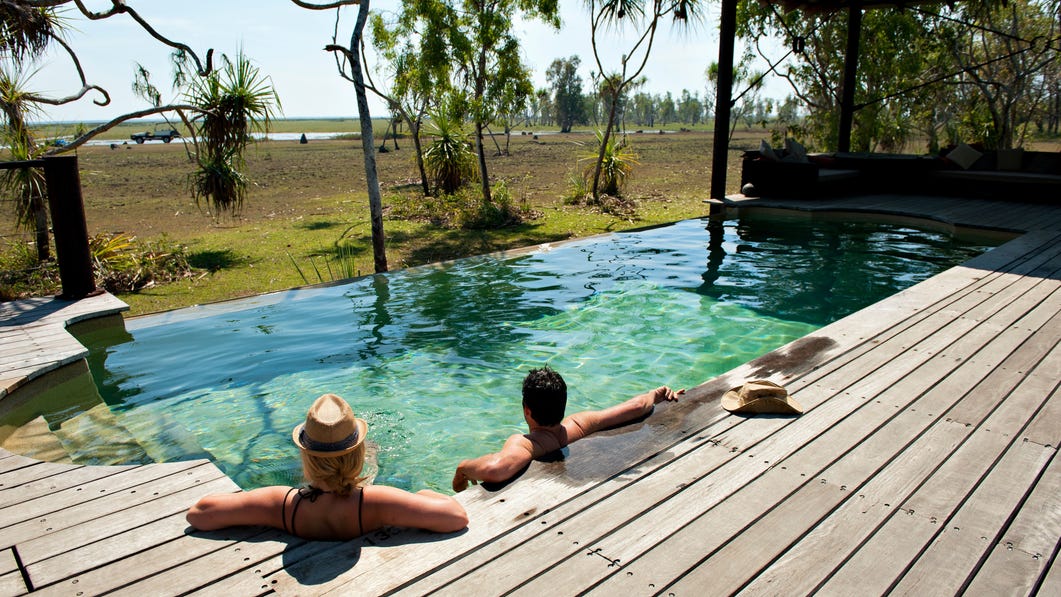 two people enjoying the pool and the view at Bamurru Plains