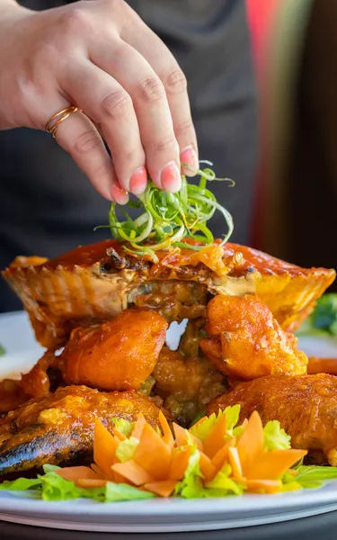 Chef decorating a cooked chilli crab at the Darwin Noodle House