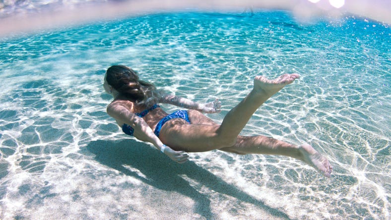 A girl swimming underwater in the wave pool at Darwin Waterfront