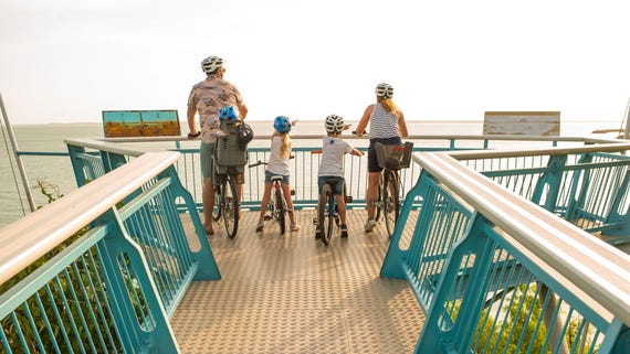 A family cycling in Bicentennial Park in Darwin