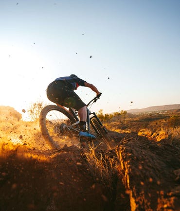 Person skidding dirt while mountain biking in Alice Springs