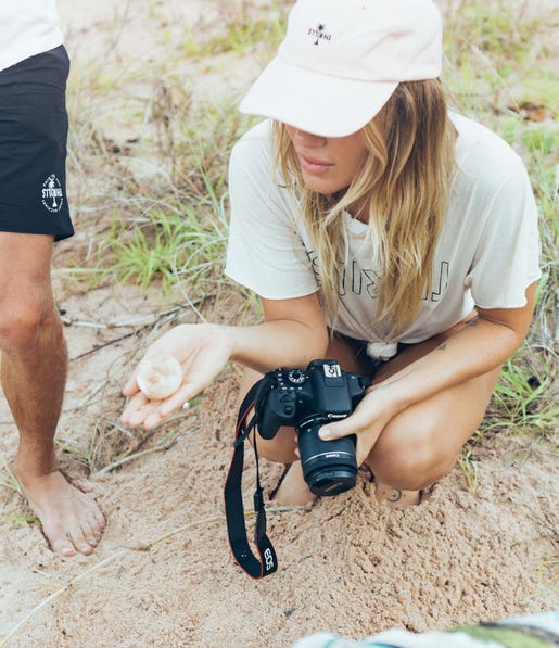 Emily Hutchinson holding a turtle egg on the Tiwi Islands Clearwater Island Lodge Marine Culture Tour