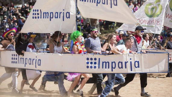 Group of people dressed up carrying a boat at the Henley on Todd Regatta in Alice Springs