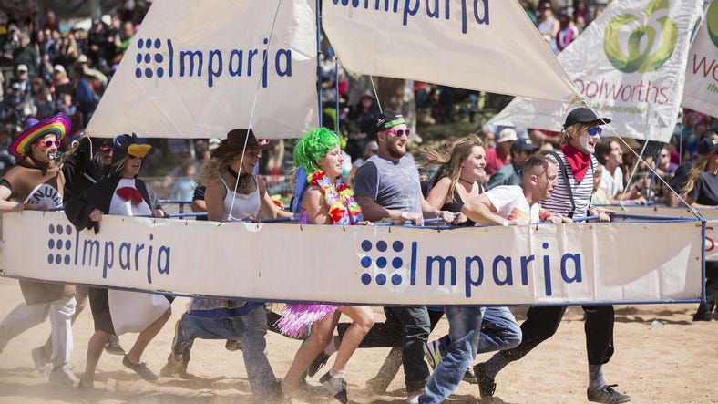 Group of people dressed up carrying a boat at the Henley on Todd Regatta in Alice Springs