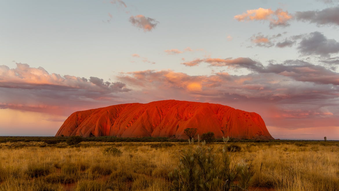 Uluru set amongst an outback sunset