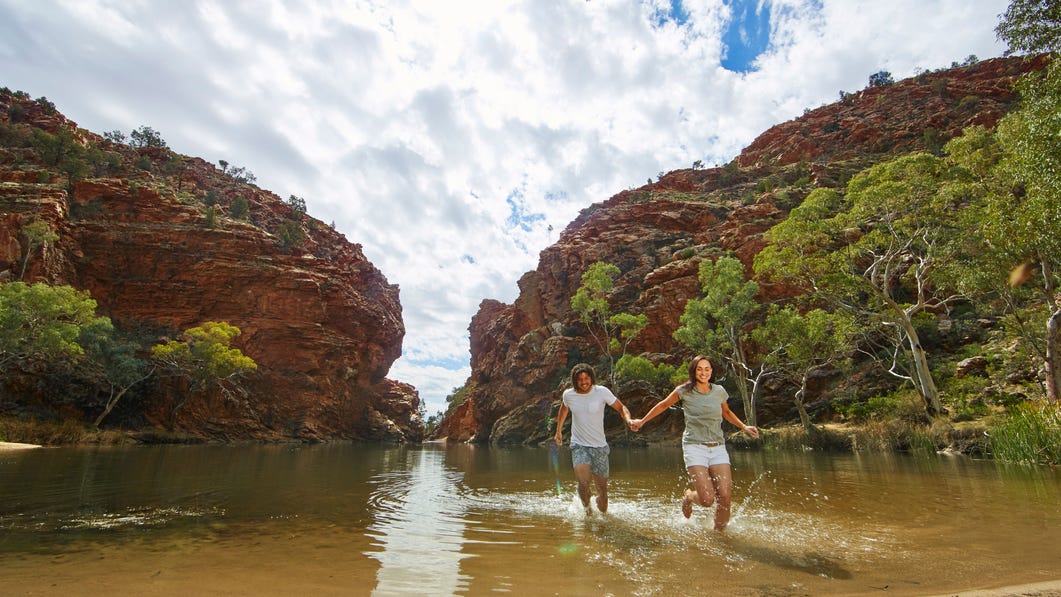 A couple splashing in the waters at Ellery Creek Big Hole near Alice Springs