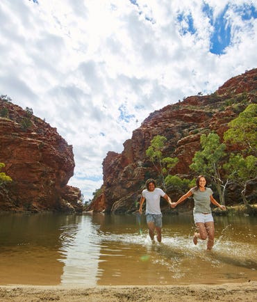 A couple splashing in the waters at Ellery Creek Big Hole near Alice Springs