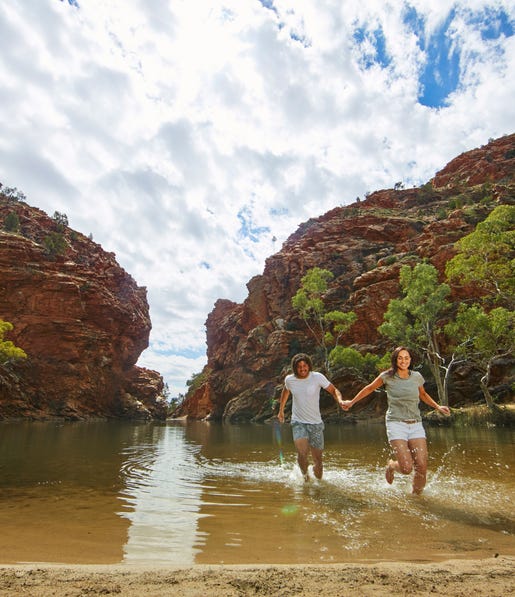 A couple splashing in the waters at Ellery Creek Big Hole near Alice Springs
