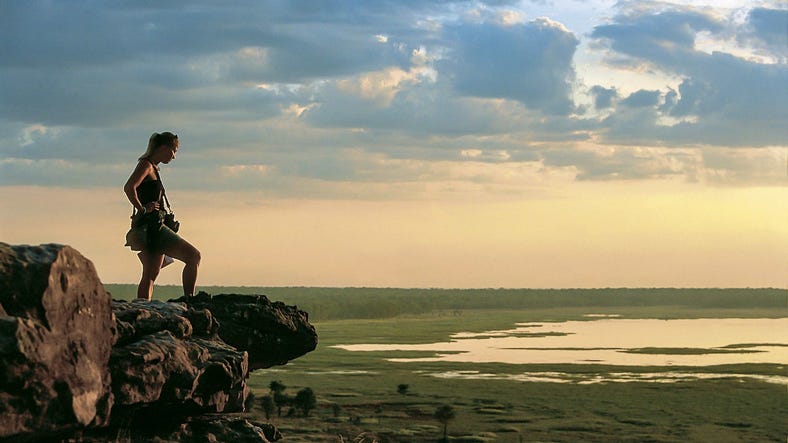 Person standing on rock looking out at the scenery in Ubirr