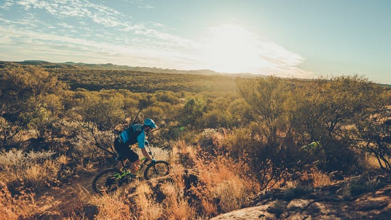 a single mountain biker riding across the rugged terrain near alice springs,-d-,jpg