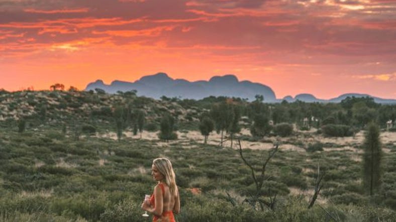 Girl enjoying a fiery sunset behind kata tjuta.jpg