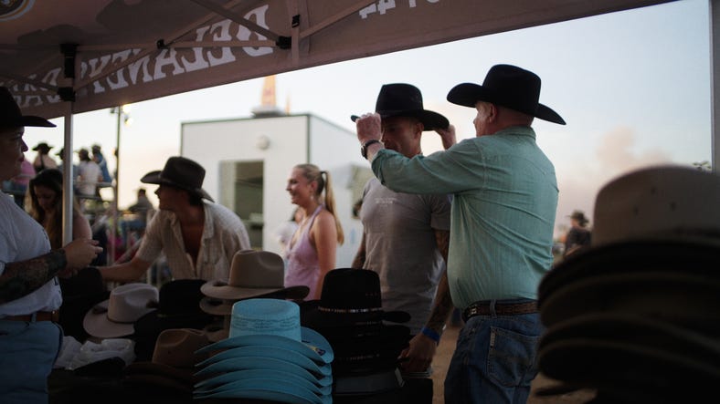Man buying hat at rodeo
