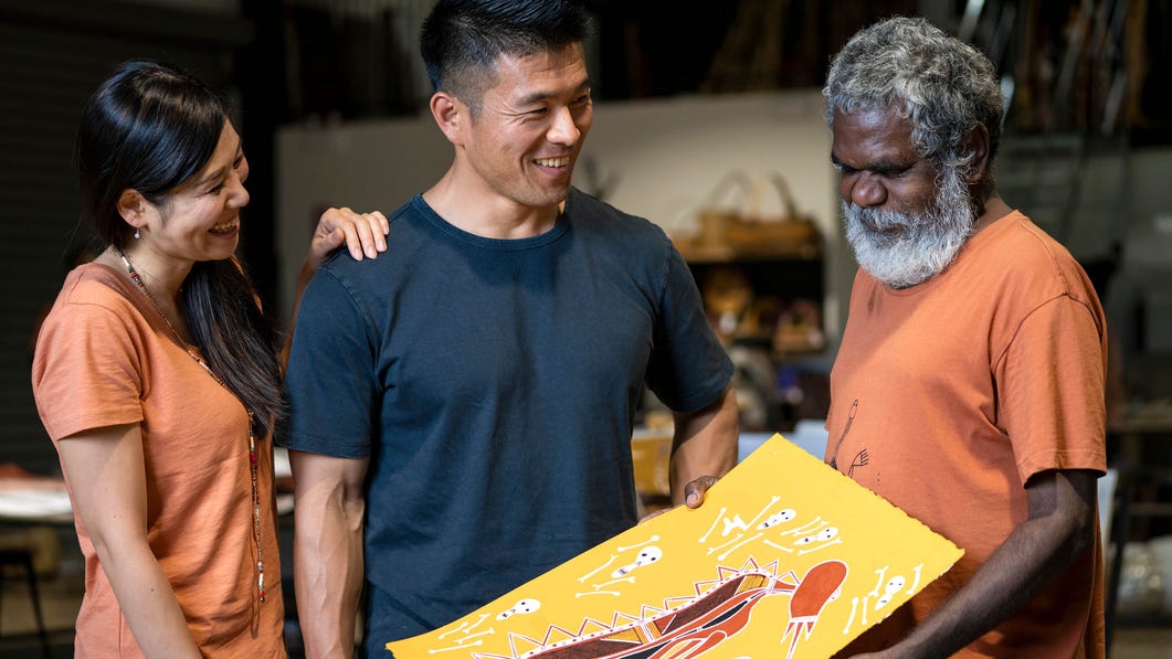indigenous artist sharing artwork with couple at murrawuddi arts and culture