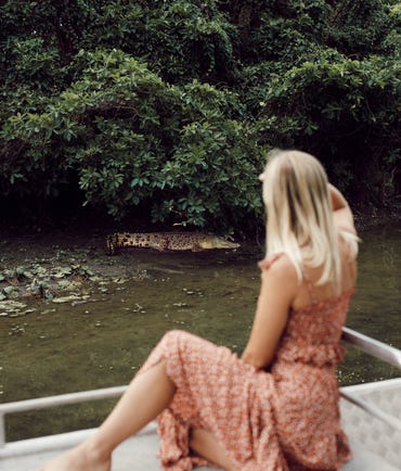 A woman watching a crocodile from Billabong cruise
