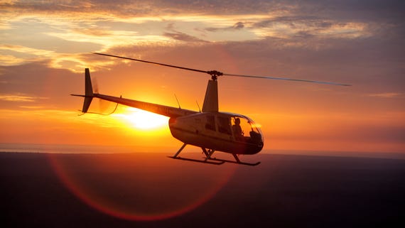 Helicopter in flight at sunset