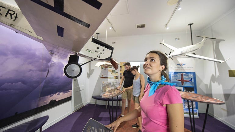 Girl looking at a plane model at the Royal Flying Doctor Service Tourist Facility