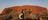 a couple taking a photo in front of Uluru