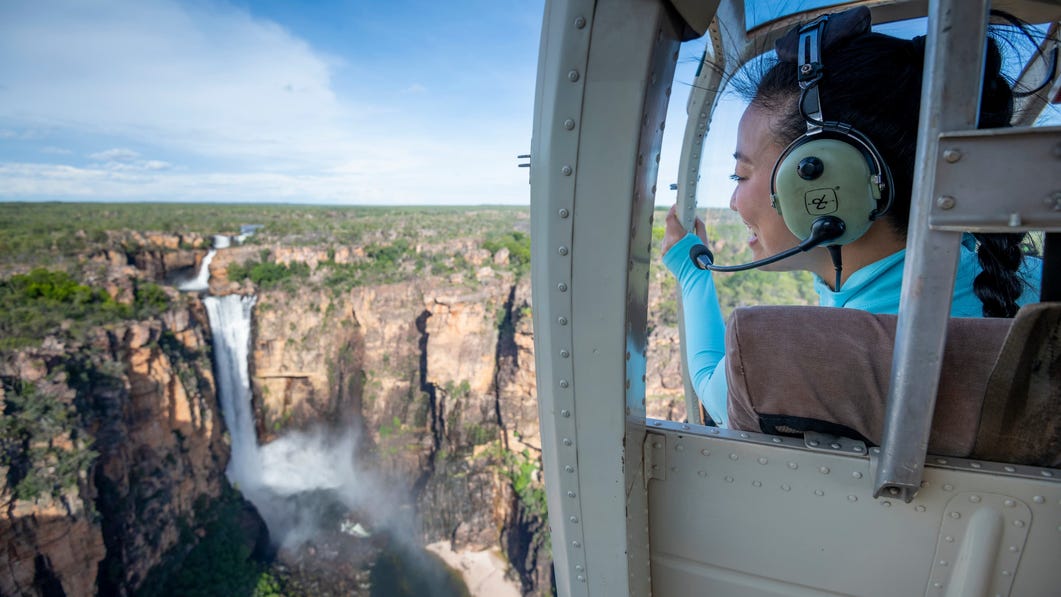 Woman looking at waterfall fromHelicopter