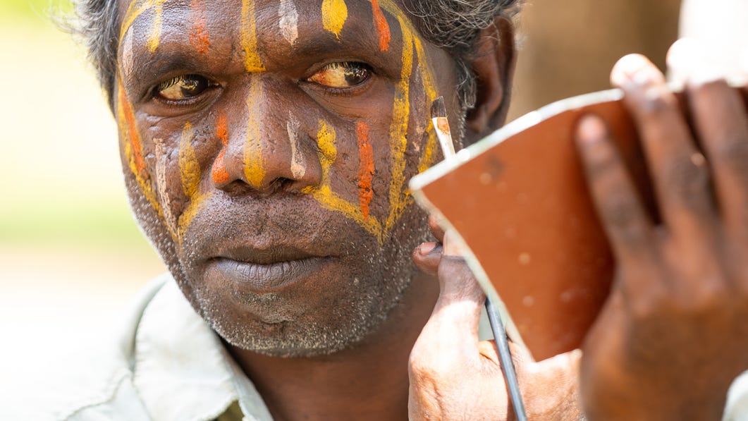 An Aboriginal man applying ceremonial face paint in the Tiwi Islands near Darwin
