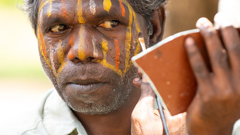 An Aboriginal man applying ceremonial face paint in the Tiwi Islands near Darwin