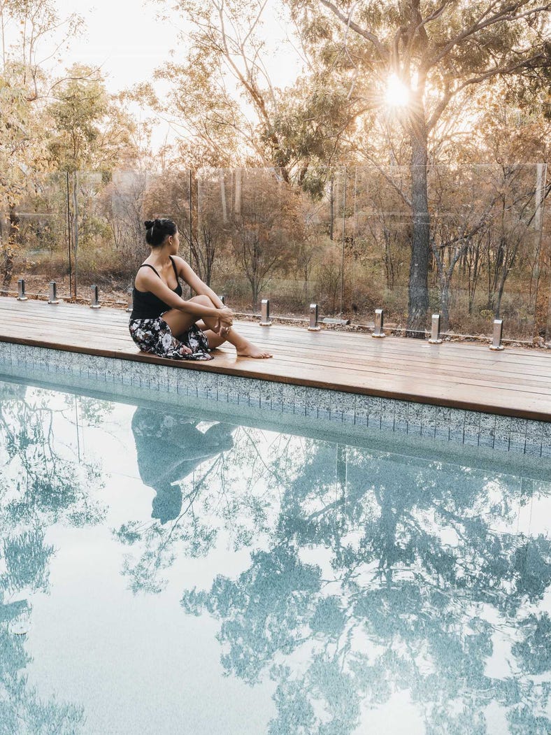 Person sitting by the pool at the Cicada lodge in Katherine