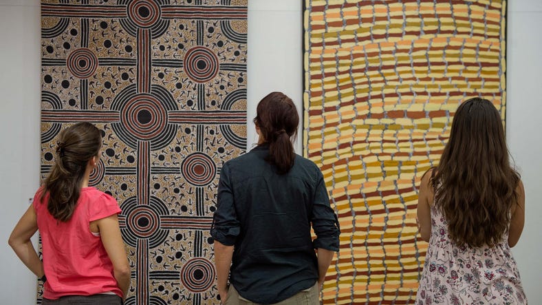 three people viewing aboriginal art work in alice springs