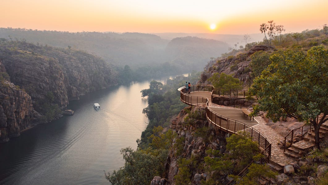 A couple observing the Katherine Gorge with a riverboat from an observation lookout