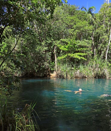 Three people swimming in the turquoise waters at Berry Springs Nature Park near Darwin