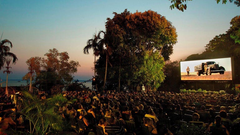 People enjoying a movie on the screen at the Deckchair Cinema with the ocean