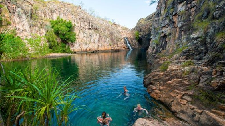 People swimming in Barramundi Gorge Waterfall