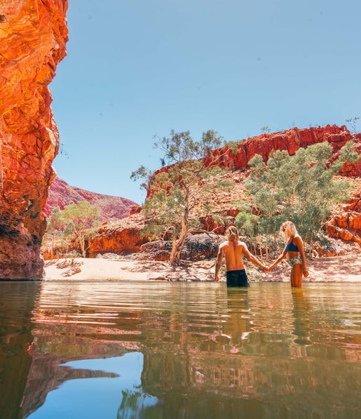 Couple standing in the water at Ormiston Gorge