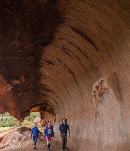 Tour group walking the base of Uluru