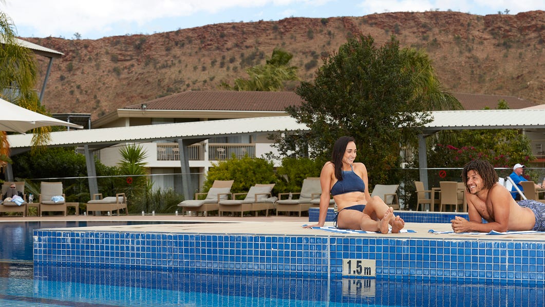 couple relaxing by the pool at crowne plaza lasseters in alice springs,-d-,jpg